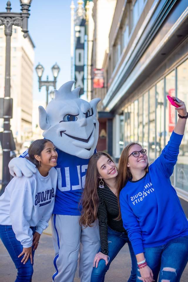 The Billiken taking a selfie with students along Grand Boulevard.