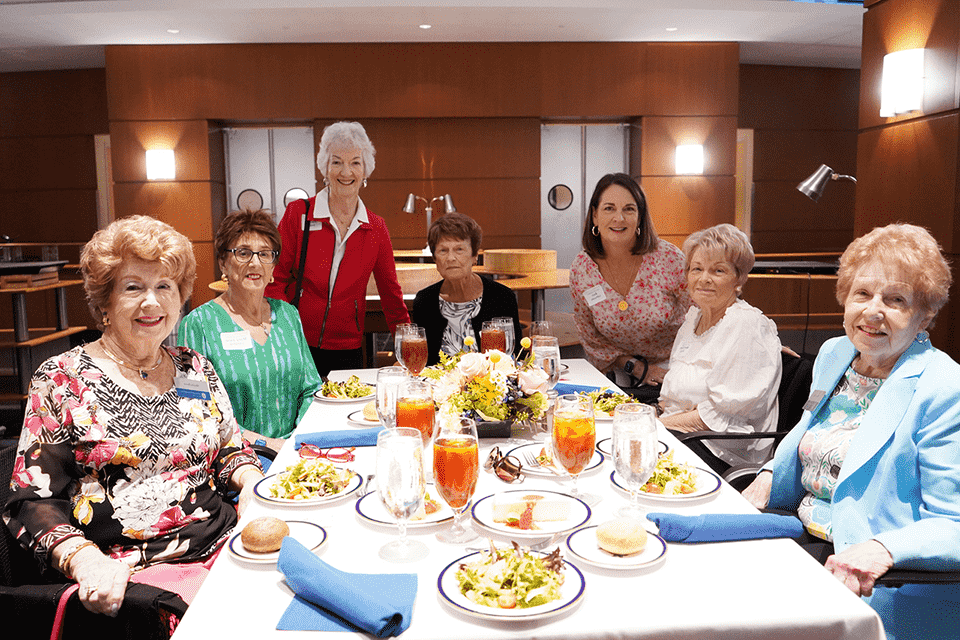 A group of women pose for a photo together at a table during the spring luncheon.