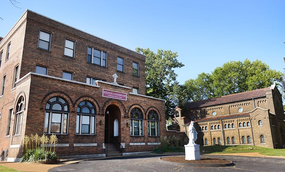 Manresa Center, a brick building with arches above the windows and an arched doorway.