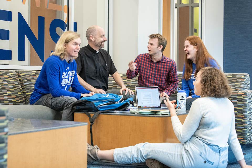 Fr. Laramie laughs with undergraduate students