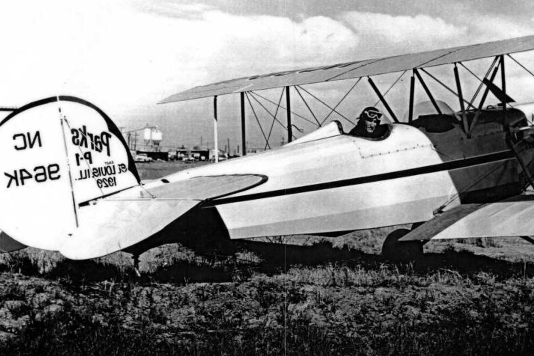 A pilot pictured in the cockpit of a historic plane with the rudder reading Parks P-1 St. Louis, Ill 2019