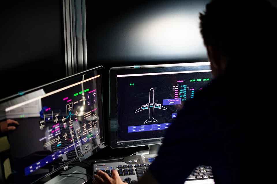 A student in profile looking at the screen of a flight simulator program