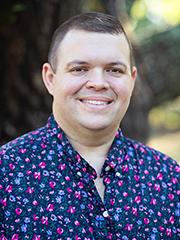 Smiling man in a colorful shirt in an outdoor setting