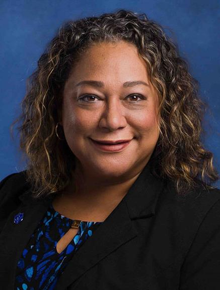 Smiling woman in black suit and blue shirt