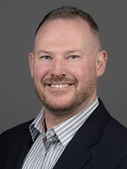 Smiling man in a white shirt and suit jacket