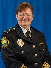 Short haired woman wearing a 博彩网址大全 Public Safety captain uniform, photographed against a solid background